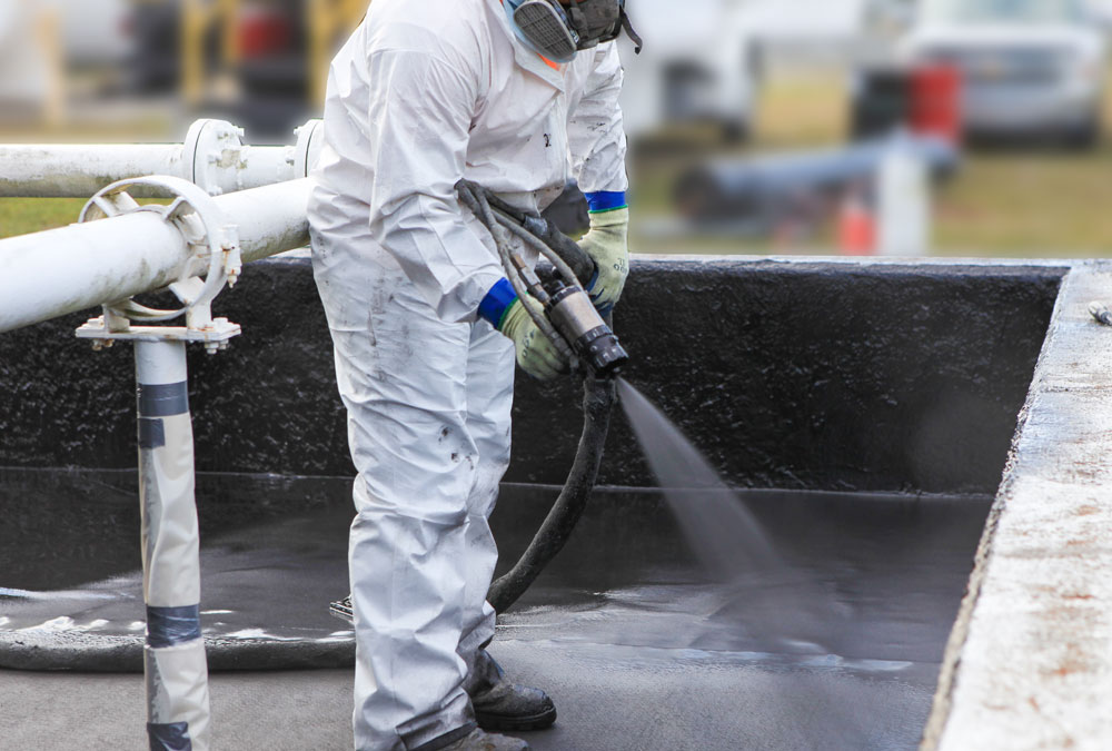 Technician applying a polyurea protective coating on a Kansas City project