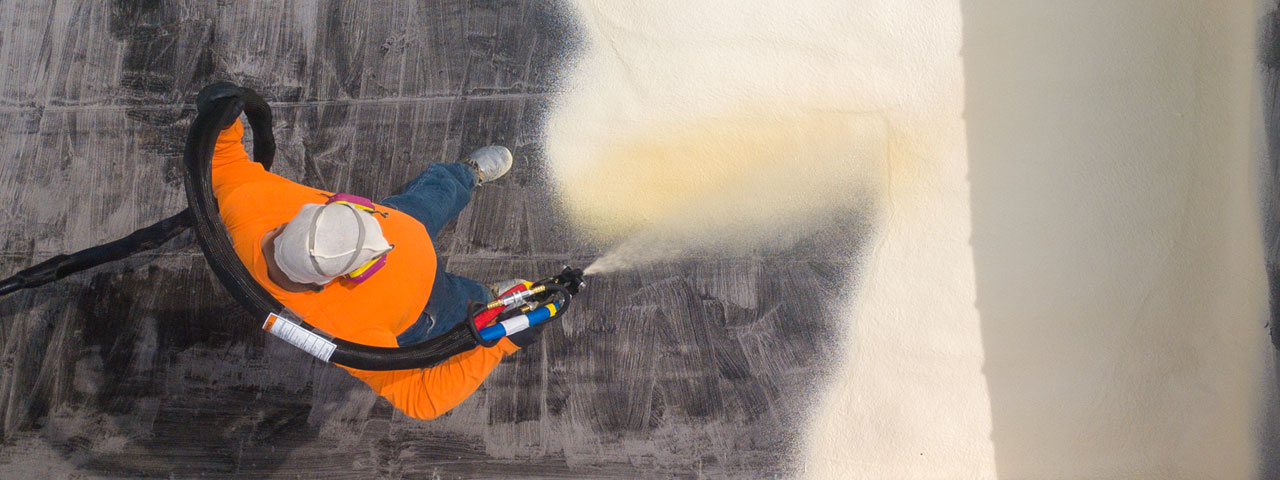 Aerial view of a seamless spray foam roofing system on a commercial flat roof in Kansas City
